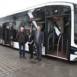 Drei Personen stehen vor einem modernen elektro bus mit der Aufschrift "Brodscheim".