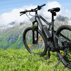 Ein E-Bike steht auf einer Bergwiese, bereit für Abenteuer. Mit diesem **Fahrrad statt Auto** die Natur erkunden.