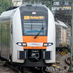 Ein moderner Zug der SPNV Linien NRW fährt auf Gleisen. Die Anzeige zeigt "RE1 Aachen Hbf".