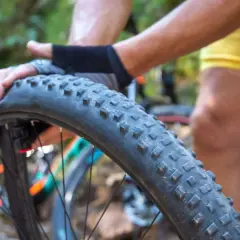 Radfahrer wechselt einen platten Fahrradreifen im Wald.