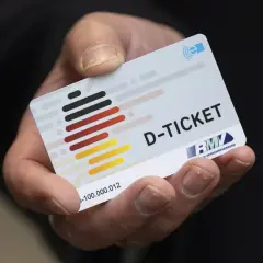Ein Daumen hält ein D-Ticket, das Deutschlandticket auf dem Handy.