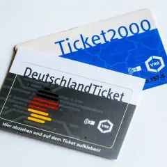 Zwei Fahrkarten liegen übereinander: das Deutschlandticket und ein Ticket2000. Sie zeigen, wie lange man mit einem Einzelticket fahren kann.