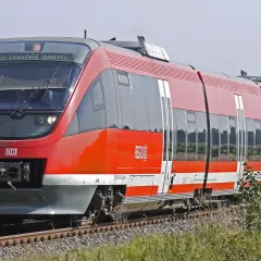 Roter Regionalexpress der DB fährt durch Kornfelder. Mit dem Deutschlandticket ist diese Fahrt ein Vergnügen.