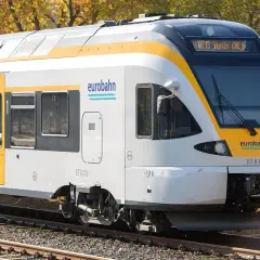 Der Eurobahn RE13 fährt durch eine herbstliche Landschaft.