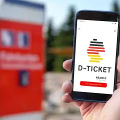 Smartphone zeigt D-Ticket App mit Preis und Kaufbutton. Verschiedene Deutschlandticket zahlungsarten sind möglich.