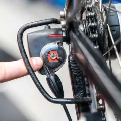Finger dreht an Einstellschraube, um die Nabenschaltung am Fahrrad zu justieren.