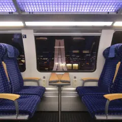 Zwei blaue Sitze der 1. Klasse im Zug, bereit für die Fahrt. Mein re1 ticket ist gelöst.