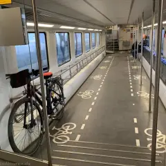 Fahrradmitnahme DB kostenlos: Ein Fahrrad steht im Gang eines Zuges, markiert mit Fahrradsymbolen auf dem Boden.