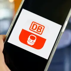 Hand hält Smartphone mit DB-App. Hier kann man unkompliziert ein DB Ticket stornieren.