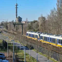 Zwei blaue und gelbe Züge der RB37 NRW fahren auf den Gleisen. Im Hintergrund ein Wasserturm und ein Sendemast.