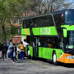 Menschen warten auf den Flixbus, der nicht kommt. Wo anrufen? Der grüne Doppeldeckerbus steht bereit, doch die Fahrgäste sind unsicher.