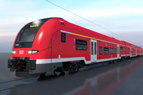 Ein roter Desiro HC Zug der Deutschen Bahn fährt auf den Gleisen.