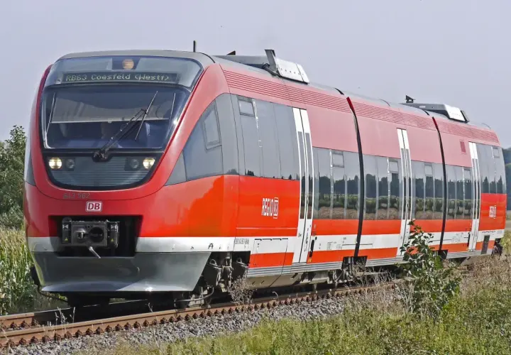 Roter Regionalexpress der DB fährt durch Kornfelder. Mit dem Deutschlandticket ist diese Fahrt ein Vergnügen.