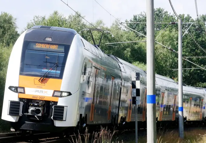 Der Rhein-Express fährt auf einer Sonderfahrt durch eine grüne Landschaft.