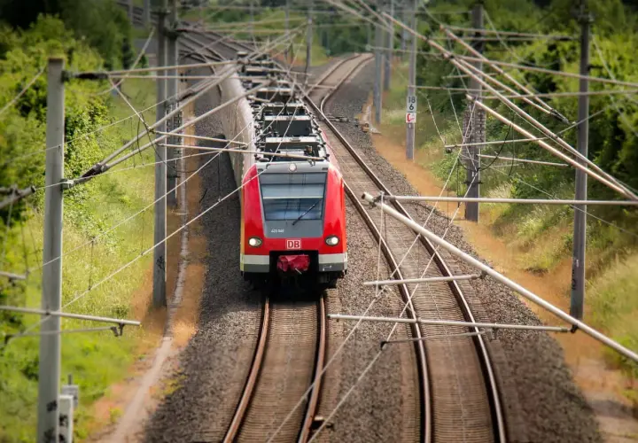 Rote DB-Bahn fährt auf Gleisen. Hier kann man alte Fahrscheine umtauschen, wenn man die Reise neu plant.