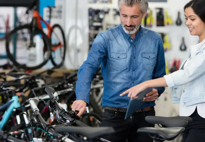 Beratung im Fahrradladen: Ein Mann und eine Frau besprechen Modelle. Gute Vansprint Erfahrungen sind hier garantiert.