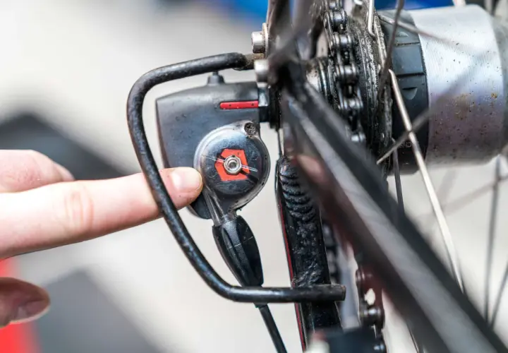 Finger dreht an Einstellschraube, um die Nabenschaltung am Fahrrad zu justieren.