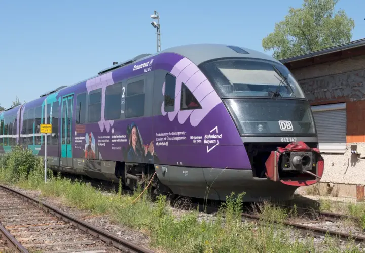 Der Triebzug br 642 mit der Nummer 642147 steht auf Gleisen, die Seiten sind lila und türkis bemalt.
