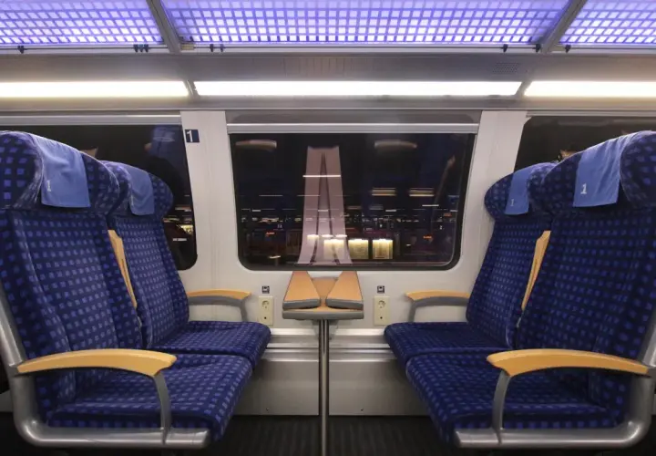 Zwei blaue Sitze der 1. Klasse im Zug, bereit für die Fahrt. Mein re1 ticket ist gelöst.