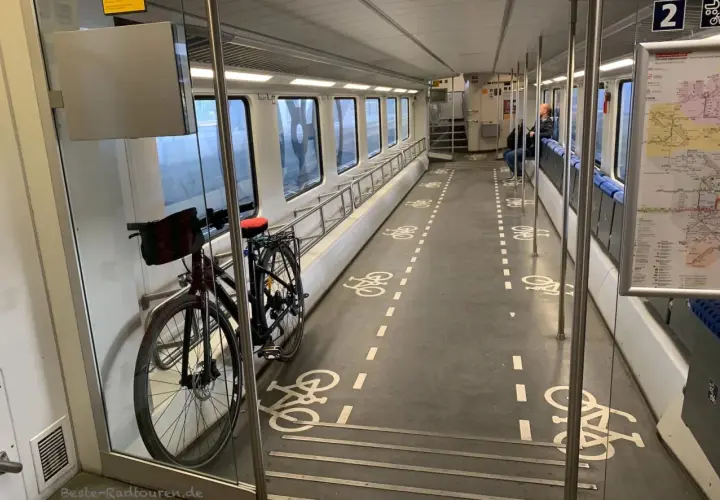 Fahrradmitnahme DB kostenlos: Ein Fahrrad steht im Gang eines Zuges, markiert mit Fahrradsymbolen auf dem Boden.