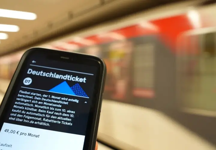Smartphone zeigt Deutschlandticket-App. Die Frage "wann wird das Deutschlandticket abgebucht" wird beantwortet: Automatisch am Monatsende, kündbar bis zum 10.
