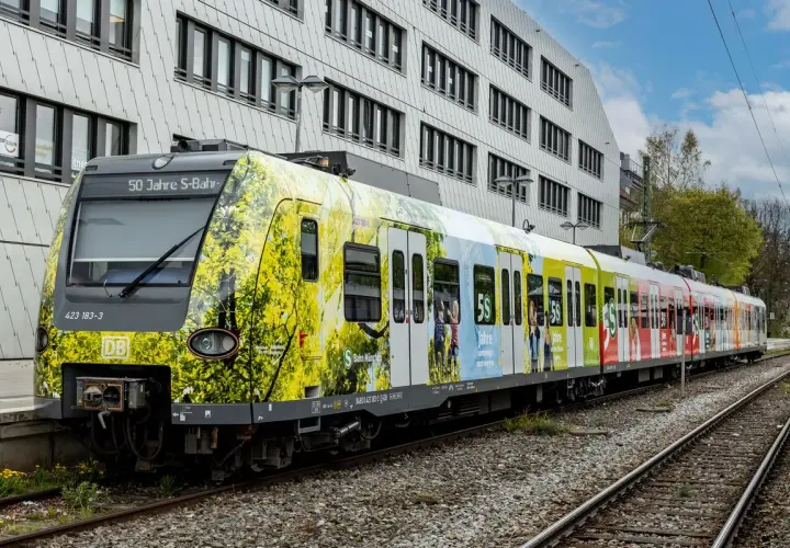 Der br 423 Zug feiert 50 Jahre S-Bahn München mit einer bunten Folierung, die Naturmotive und Jubiläumslogos zeigt.