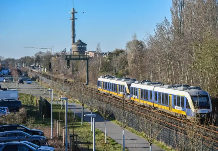 Zwei blaue und gelbe Züge der RB37 NRW fahren auf den Gleisen. Im Hintergrund ein Wasserturm und ein Sendemast.