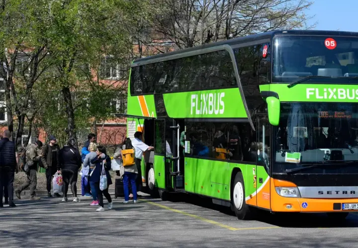 Menschen warten auf den Flixbus, der nicht kommt. Wo anrufen? Der grüne Doppeldeckerbus steht bereit, doch die Fahrgäste sind unsicher.