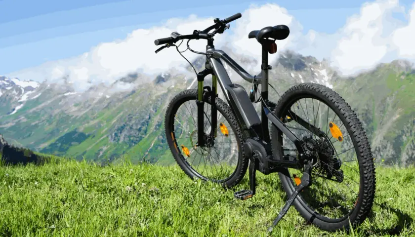 Ein E-Bike steht auf einer Bergwiese, bereit für Abenteuer. Mit diesem **Fahrrad statt Auto** die Natur erkunden.