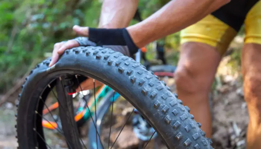 Radfahrer wechselt einen platten Fahrradreifen im Wald.