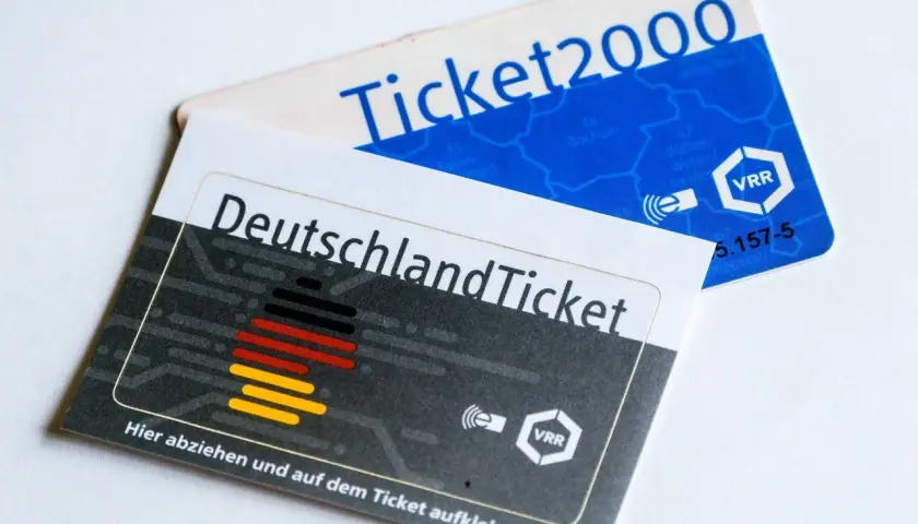 Zwei Fahrkarten liegen übereinander: das Deutschlandticket und ein Ticket2000. Sie zeigen, wie lange man mit einem Einzelticket fahren kann.