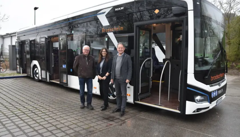 Drei Personen stehen vor einem modernen elektro bus mit der Aufschrift "Brodscheim".
