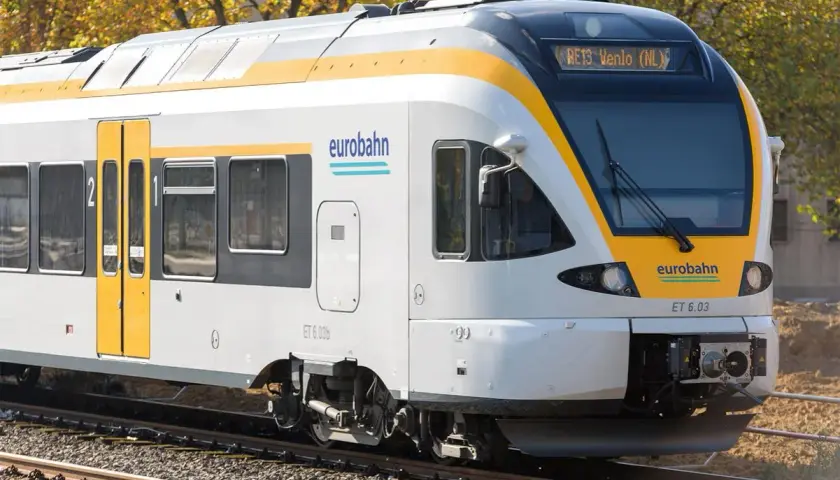 Der Eurobahn RE13 fährt durch eine herbstliche Landschaft.