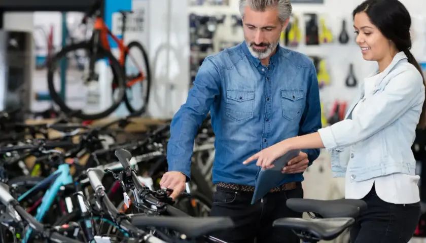 Beratung im Fahrradladen: Ein Mann und eine Frau besprechen Modelle. Gute Vansprint Erfahrungen sind hier garantiert.