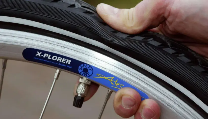 Daumen prüft den Fahrradreifen. Wie viel bar braucht der Reifen? Die Felge zeigt "X-PLORER".