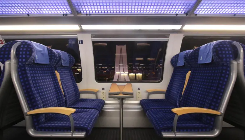 Zwei blaue Sitze der 1. Klasse im Zug, bereit für die Fahrt. Mein re1 ticket ist gelöst.