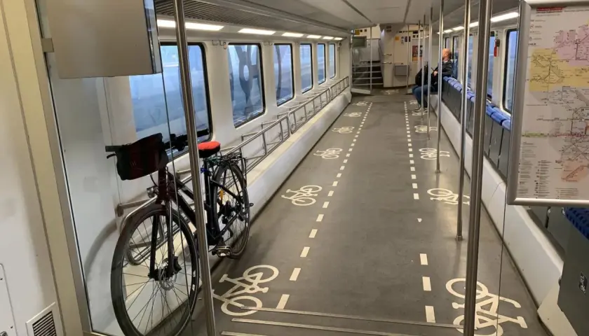 Fahrradmitnahme DB kostenlos: Ein Fahrrad steht im Gang eines Zuges, markiert mit Fahrradsymbolen auf dem Boden.