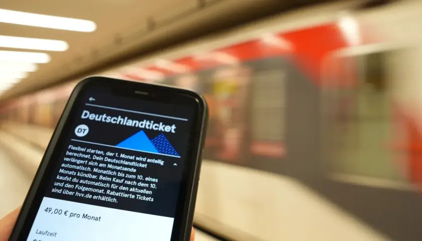 Smartphone zeigt Deutschlandticket-App. Die Frage "wann wird das Deutschlandticket abgebucht" wird beantwortet: Automatisch am Monatsende, kündbar bis zum 10.