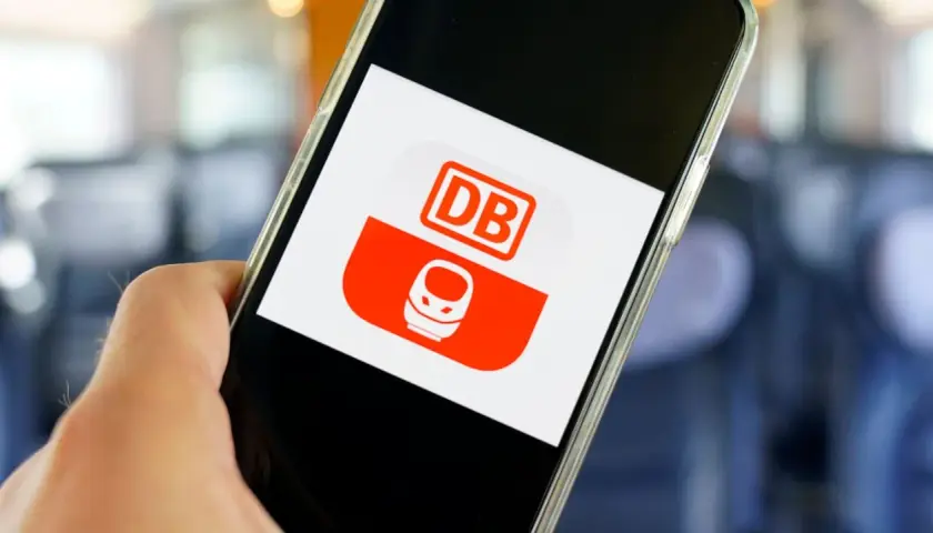 Hand hält Smartphone mit DB-App. Hier kann man unkompliziert ein DB Ticket stornieren.