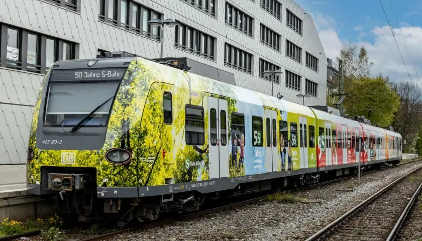 Der br 423 Zug feiert 50 Jahre S-Bahn München mit einer bunten Folierung, die Naturmotive und Jubiläumslogos zeigt.