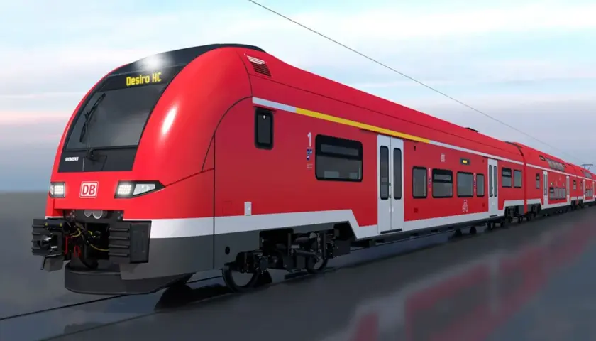 Ein roter Desiro HC Zug der Deutschen Bahn fährt auf den Gleisen.