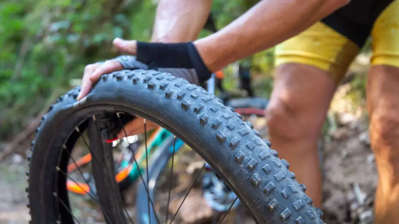 Radfahrer wechselt einen platten Fahrradreifen im Wald.