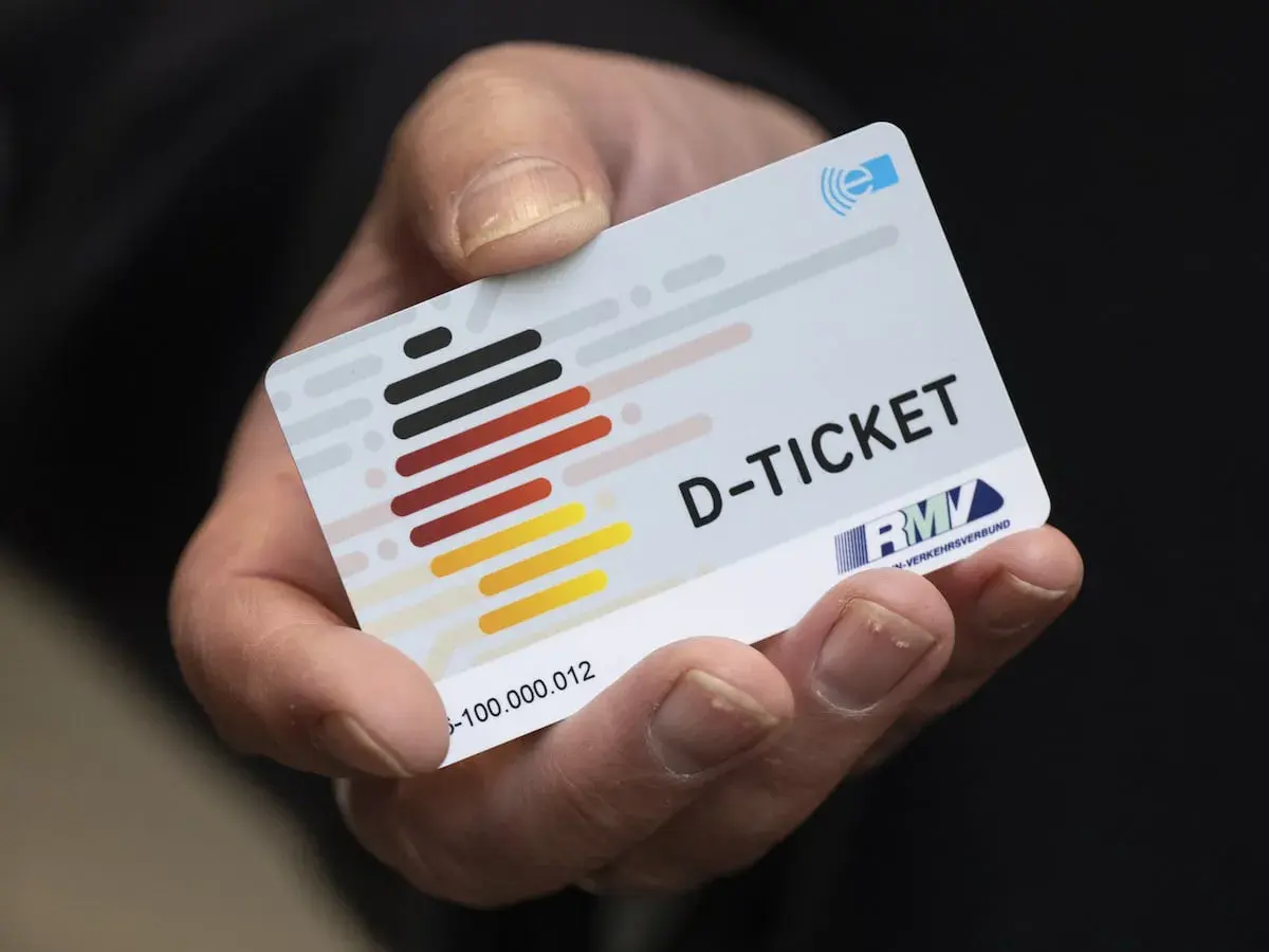 Ein Daumen hält ein D-Ticket, das Deutschlandticket auf dem Handy.
