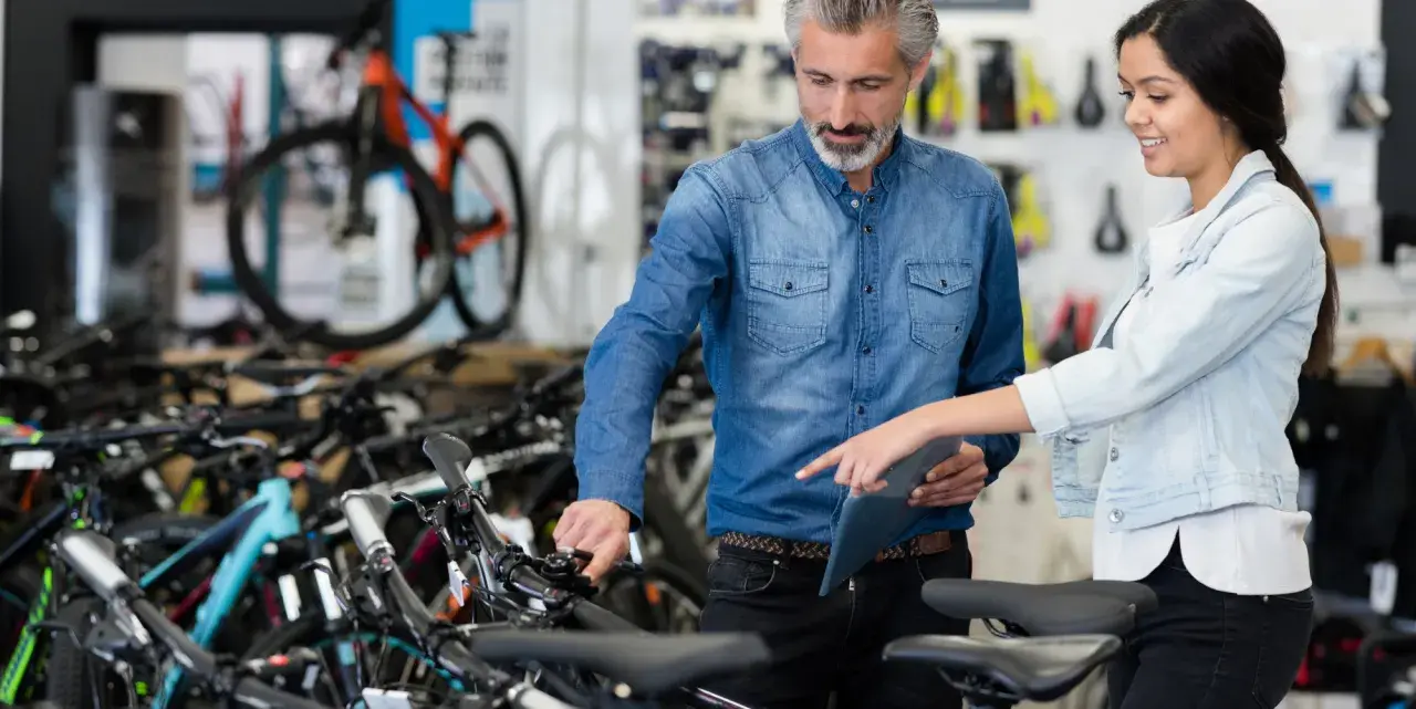Beratung im Fahrradladen: Ein Mann und eine Frau besprechen Modelle. Gute Vansprint Erfahrungen sind hier garantiert.