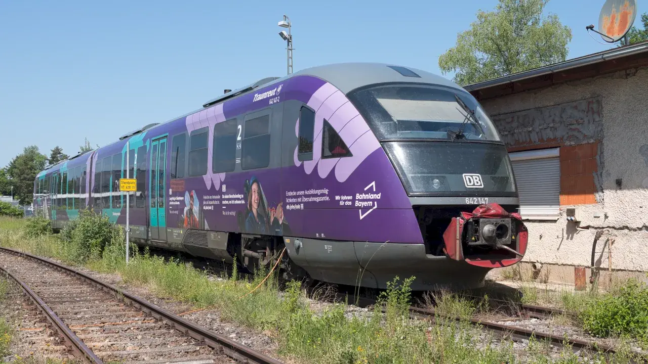 Der Triebzug br 642 mit der Nummer 642147 steht auf Gleisen, die Seiten sind lila und türkis bemalt.
