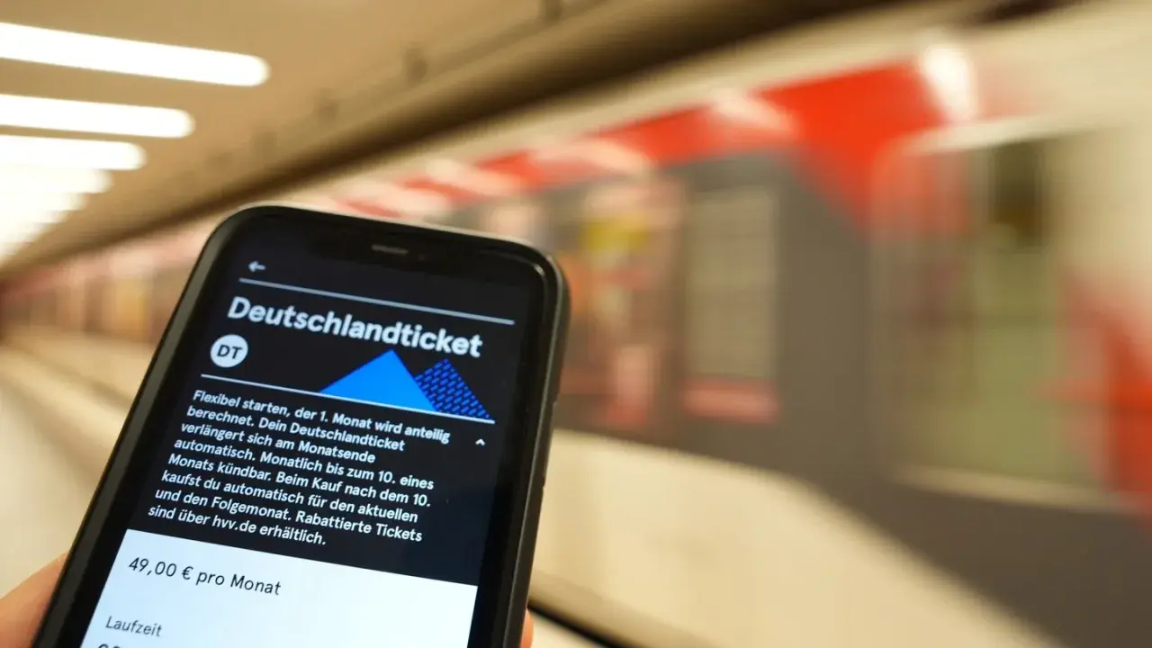 Smartphone zeigt Deutschlandticket-App. Die Frage "wann wird das Deutschlandticket abgebucht" wird beantwortet: Automatisch am Monatsende, kündbar bis zum 10.