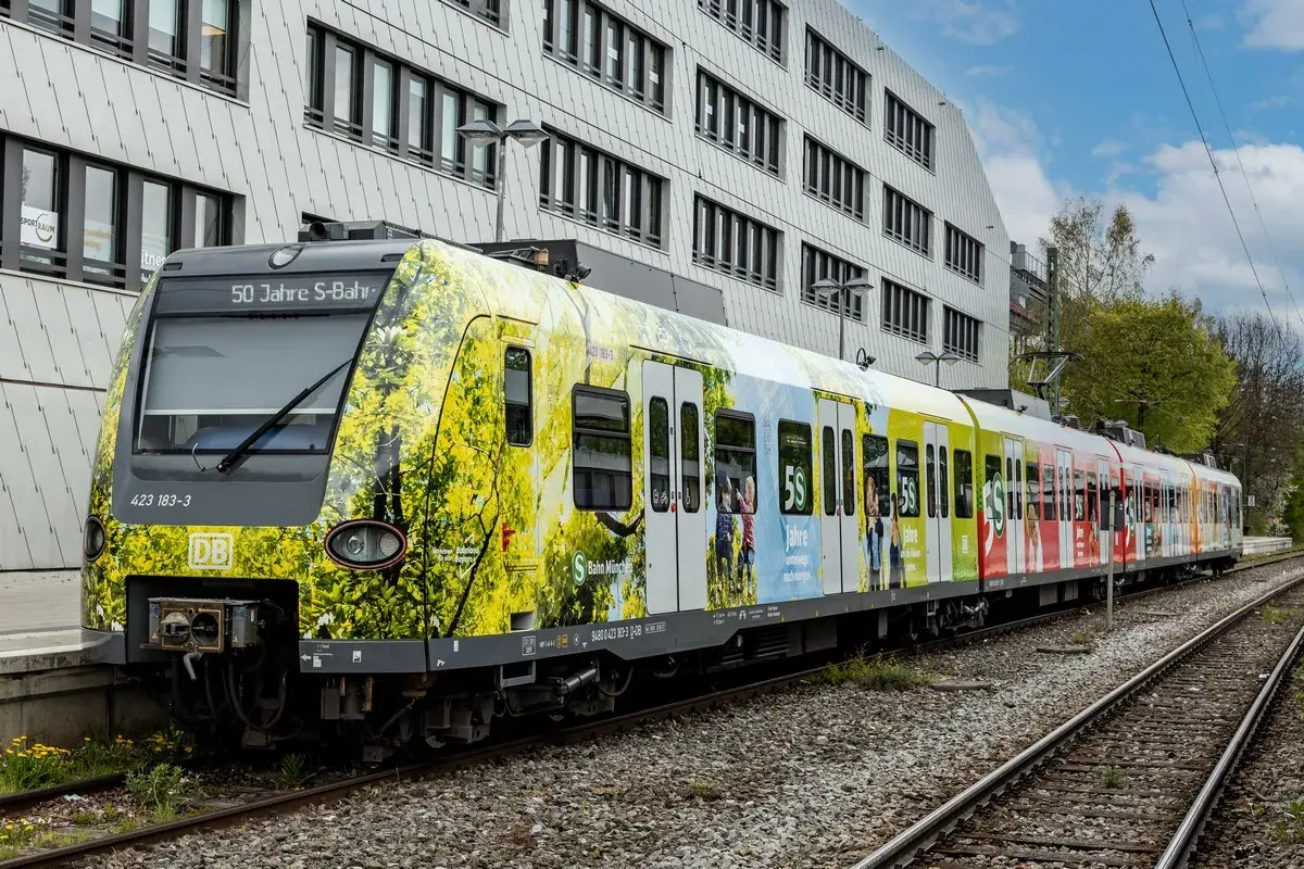 Der br 423 Zug feiert 50 Jahre S-Bahn München mit einer bunten Folierung, die Naturmotive und Jubiläumslogos zeigt.