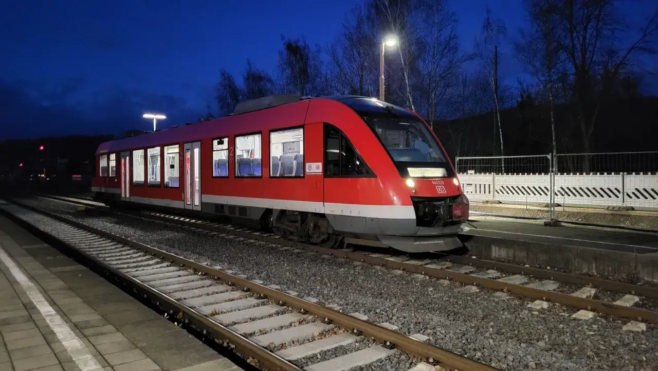 Roter Triebwagen der Baureihe 640 (LINT 27) steht nachts am Bahnsteig.
