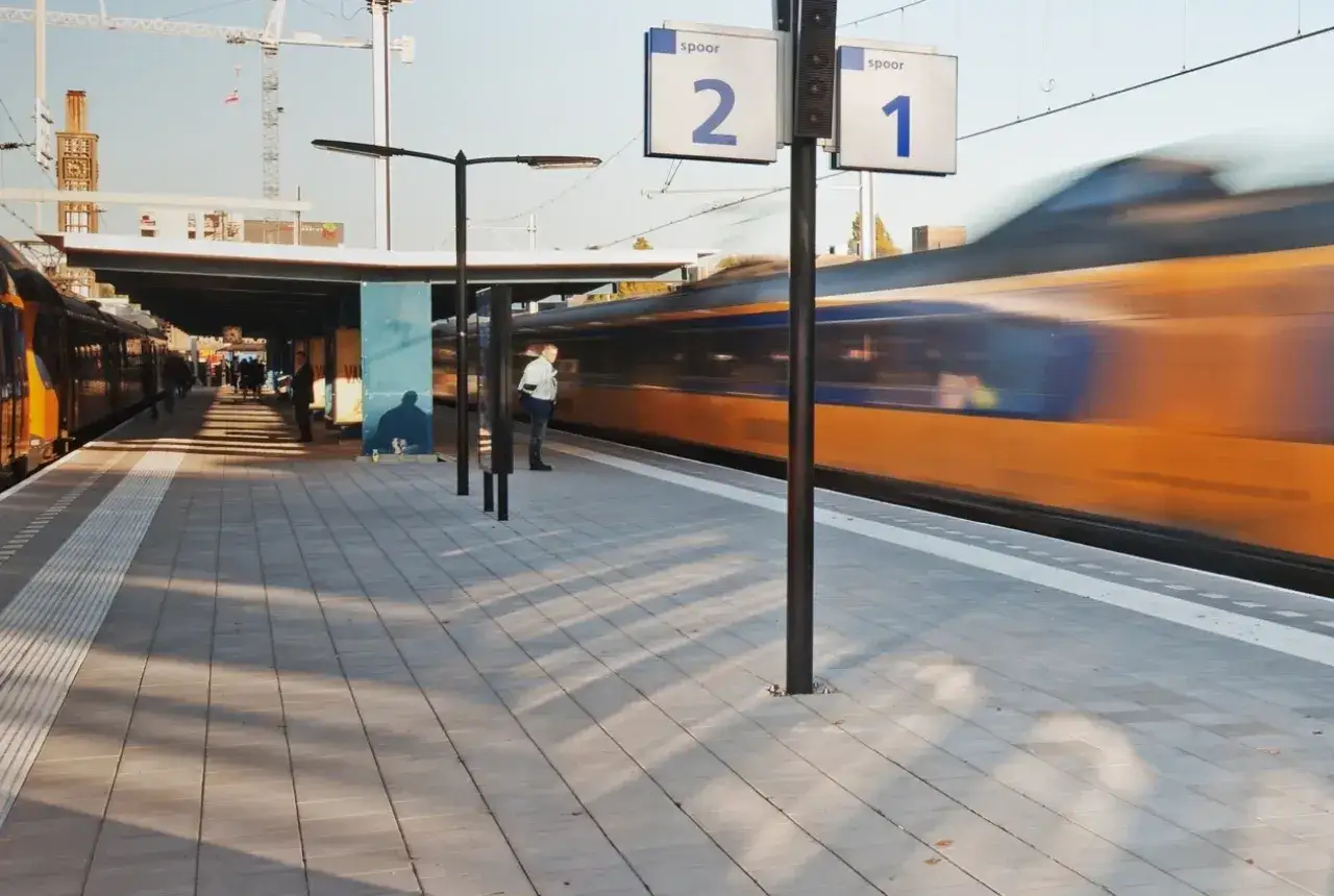 Ein Zug rast am Bahnsteig 1 in Enschede vorbei. Mit dem Deutschlandticket ist diese Reise einfach.