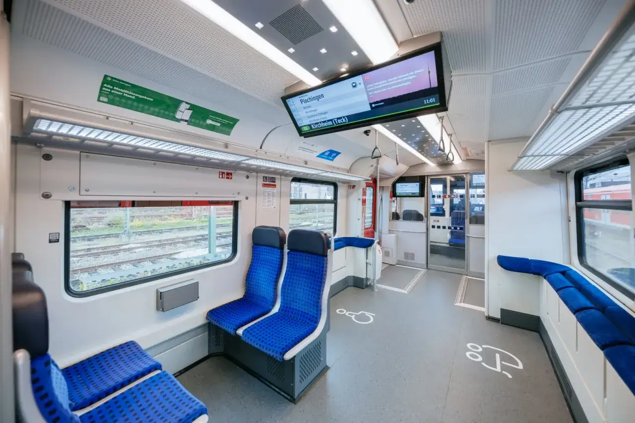 Innenraum eines modernen Triebwagens et 424 mit blauen Sitzen und einem Bildschirm, der 
